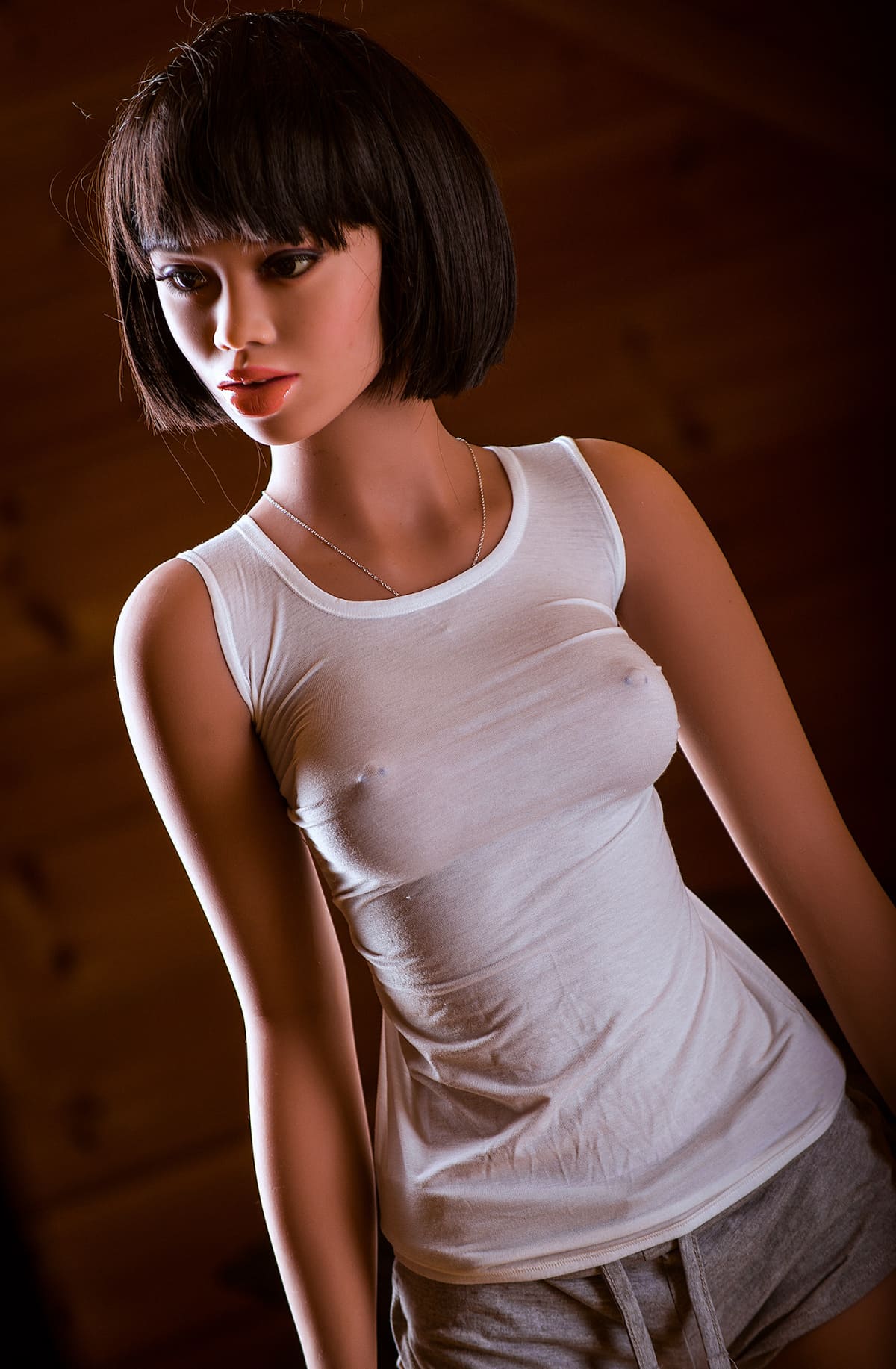Секс-лялька Nila фото 6 - SexDolls.com.ua Секс лялька Nila у білій майці та коротких шортах дивиться убік