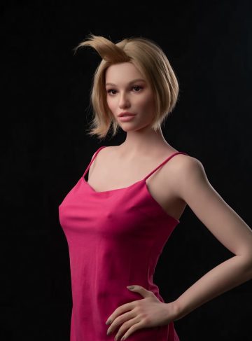 Секс-лялька Masha фото 7 - SexDolls.com.ua Секс лялька Masha в рожевій сукні стоїть біля крісла і дивиться убік