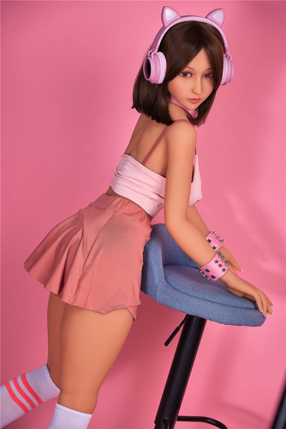 секс-лялька Marion - фото 7 - SexDolls.com.ua Секс лялька Marion біля синього стільця стоїть боком