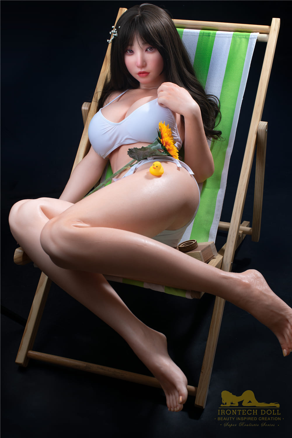 секс-лялька Suki - фото 10 - SexDolls.com.ua Секс лялька Suki сидить у купальнику на пляжному стільці