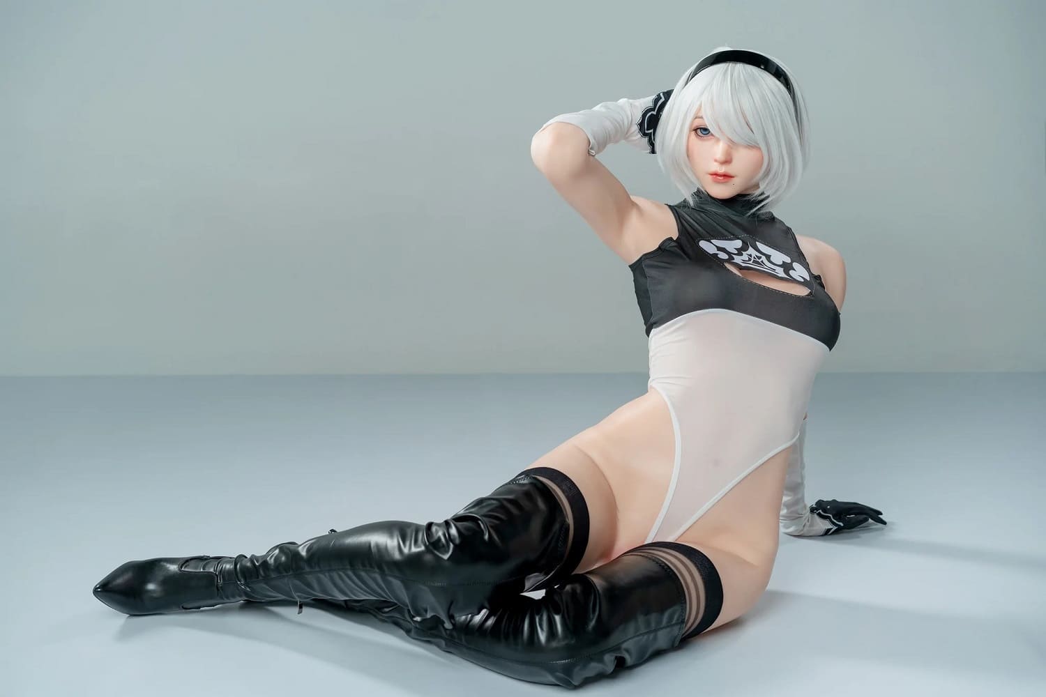 Секс-лялька Lu - фото 9 - SexDolls.com.ua Секс лялька Lu сидить на підлозі в чорних чоботах і боді