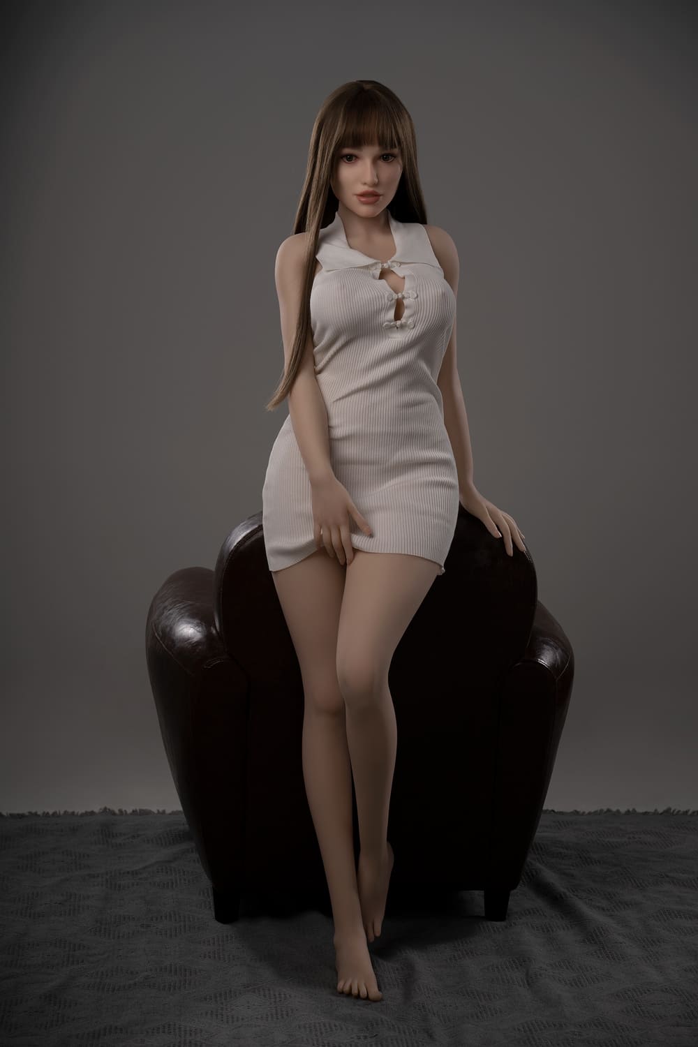 Секс-лялька Selma - фото 3 - SexDolls.com.ua Секс лялька Selma у білій сукні спирається на спинку крісла